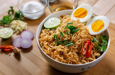 Instant noodles in bowl on wood background top view, Asian meal on a table.