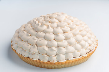 Lemon meringue pie on cutting board on white background