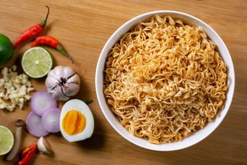 Instant noodles in bowl on wood background top view, Asian meal on a table.