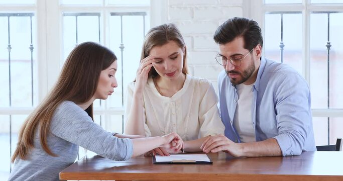 Angry young clients dissatisfied with purchase contract details, blaming real estate agent at meeting in office. Nervous family couple shouting at financial advisor, disappointed with bad offer.
