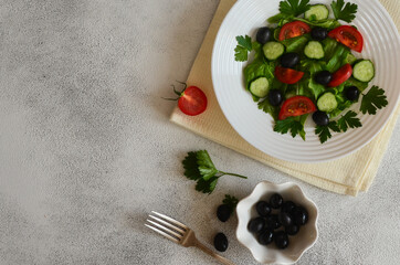 Super food fresh vegetable salad with cherry tomato cucumber black olives with parsley and lettuce top view. The concept of healthy food and dieting. Copy space text. Nutrition for a slim figure