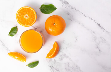 Fresh orange juice in glass and oranges fruit on white marble table background.