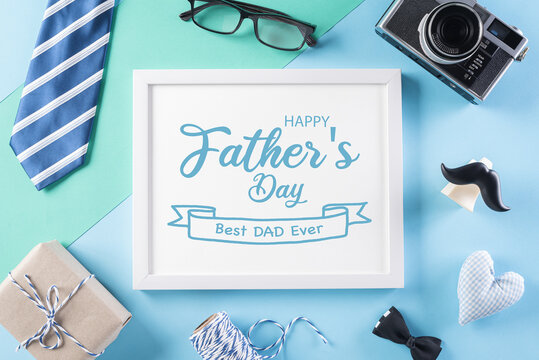 Happy Fathers Day background concept with picture frame, retro camera, decorated bowtie, necktie, eyeglasses, gift box and mustache on bright pastel background.