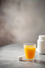 Powder collagen puts hand in glass of citrus juice.