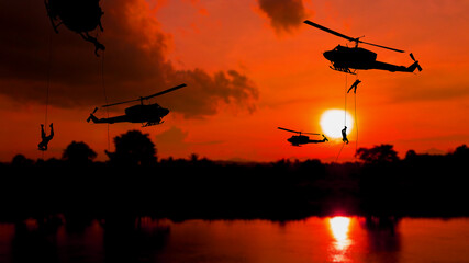 Fototapeta na wymiar soldier silhouette climb down from helicopter on sunset Concept stop warfare with copy space add text