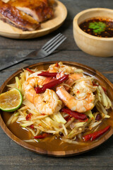 Papaya salad with pickled fish soup and shrimp in wooden table on wooden table.