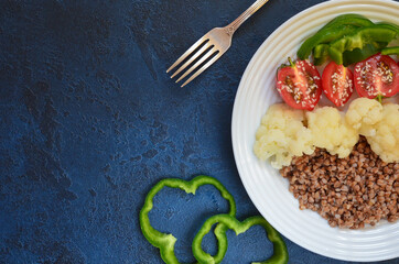 Super food buckwheat with vegetables cauliflower sweet peppers cherry tomatoes with sesame top view with space for text. Concept of healthy and vegetarian food