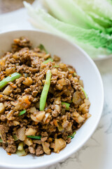 A Yummy Bowl of Stir-Fried Ground Chicken and Lettuce in the Background. 