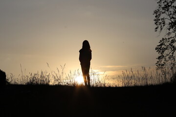 silhouette of a woman child walking in the field