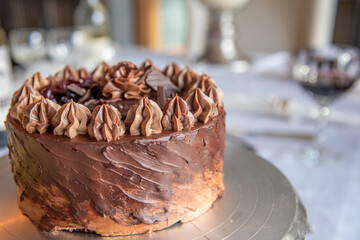Close up on beautifully decorated and presented chocolate fudge cake with stunning topping. 