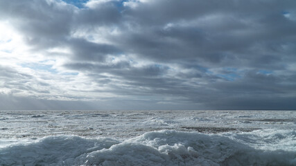 Scenery of a beautiful cloudy sky over an ice-covered pond