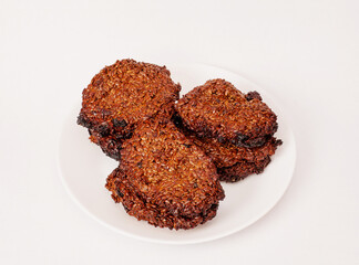 Oatmeal cookies in a white plate on a white background.