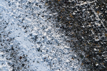 Track from car tire on asphalt covered with snow