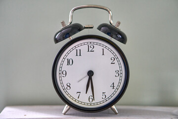 Black watch. alarm clock. 5: 29 clock hands. Half past five. It is half past five. The time is 5:30...