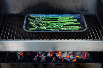 Grüner Spargel zum Grillen, barbecue mit Olivenöl, Kräutern und Gewürzen auf dem Grill, Draufsicht. Gesunde Ernährung Konzept, vegan. Selektive Schärfe