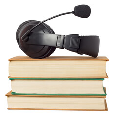 Headphones with a microphone and a stack of books isolated on white background.