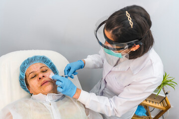 Applying injections with security measures. Beauty salon center. Pandemic coronavirus. Platelet...