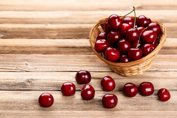 Sweet cherries in basket on brown wooden table