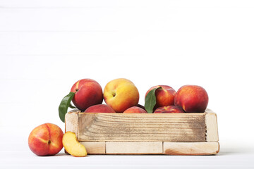 Fresh peaches in crate on white background
