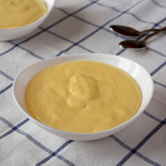 Homemade vanilla custard pudding in white bowls, low angle view. Close-up.