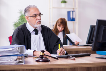 Old male judge and his young secretary in the office
