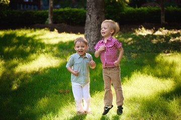 Fototapeta premium Two boys brothers playing and jumping outdoors in a park.