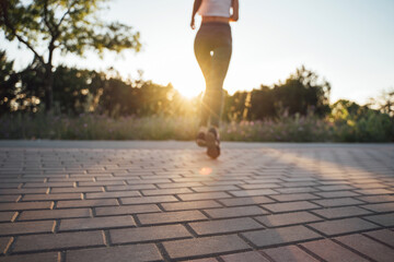 The girl runs from the side of the sunset on the path