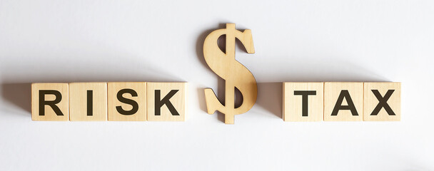 Wooden blocks with the word RISK or TAX . Make the right decision. Real estate concept. Rent apartment. Property.
