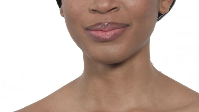Close-up of a beautiful female model touching lips. Beauty concept. Isolated, on white background
