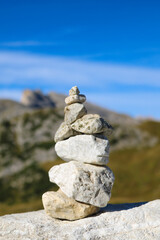 Tower of stones to make a wish stands on the top of the rock. Selective focus.