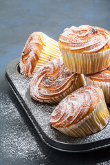 Muffins in powdered sugar in a baking pan