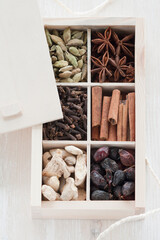set of spices in a box on a wooden background