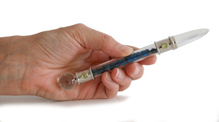 Holding Quartz Cavansite Crystal Wand - Female hand holding wand isolated against white background 
