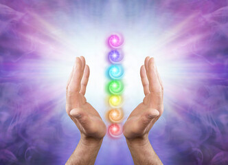 Sending You Seven Chakra Healing Energy - Male parallel hands facing upwards against a purple...