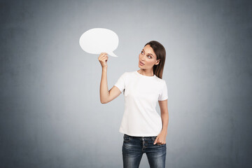 Astonished woman holding blank speech bubble