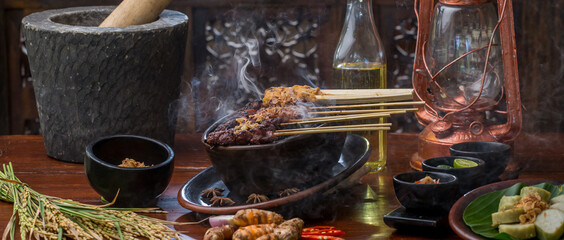 Satay or sate, skewered grilled meat, served with peanut sauce and spicy sauces. Malaysia or Indonesia food. Asian cuisine.