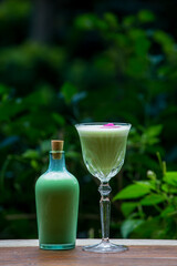 Green alcohol cocktail with foamy egg white