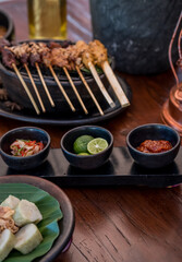 Satay or sate, skewered grilled meat, served with peanut sauce and spicy sauces. Malaysia or Indonesia food. Asian cuisine.