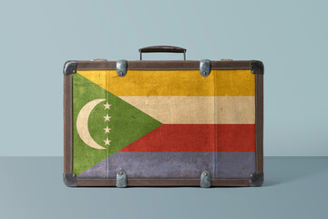 Comoros flag on old vintage leather suitcase with national concept. Retro brown luggage with copy...