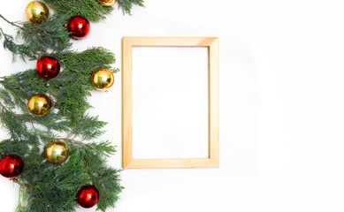 Christmas wooden frame juniper gold and red balls n white background top view