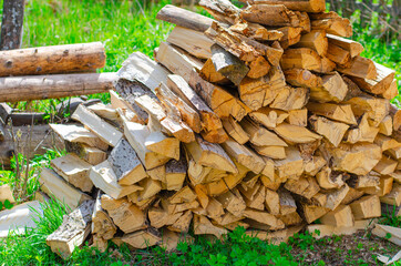 A pile of wood for kindling. Big pile of firewood. Deforestation, forest clearing, in the backyard and forest. 