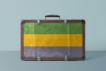 Gabon flag on old vintage leather suitcase with national concept. Retro brown luggage with copy...