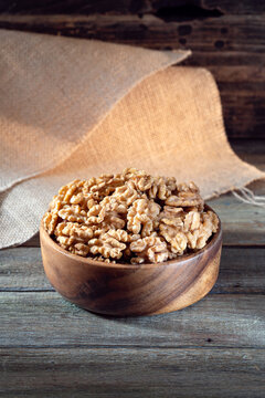 Walnuts in round bowl on wooden rustic background 