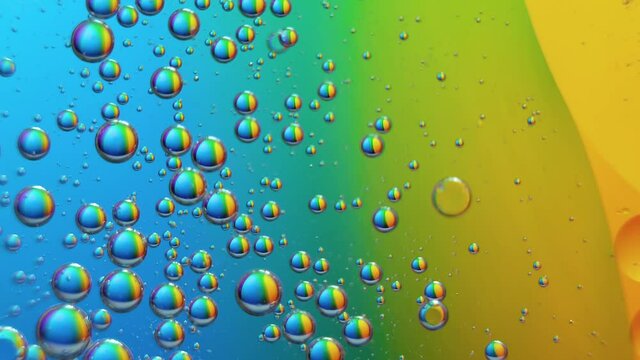 Top view movement of oil bubbles. Oil surface multicolored background. Fantastic structure of colorful bubbles. Abstract colorful background. Closeup bubbles in water.
