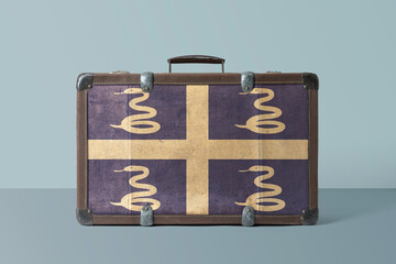 Martinique flag on old vintage leather suitcase with national concept. Retro brown luggage with copy space text.