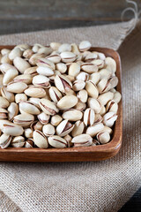 Pistachios in wooden bowl on rustic background 