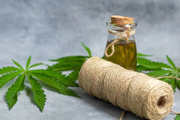 A thread made from cannabis and hemp leaves on a gray background.