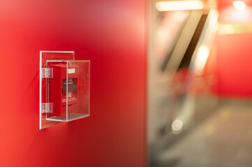 The red fire alarm switch on the red wall at the Bangkok subway.