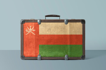 Oman flag on old vintage leather suitcase with national concept. Retro brown luggage with copy space text.