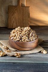 Walnuts in round bowl on wooden rustic background 